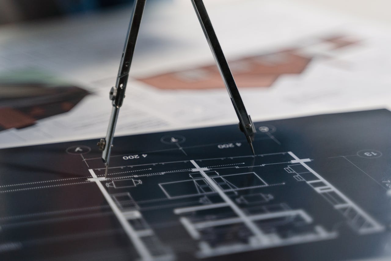 home-services-004 A compass on architectural blueprints, showcasing planning and measurement details.
